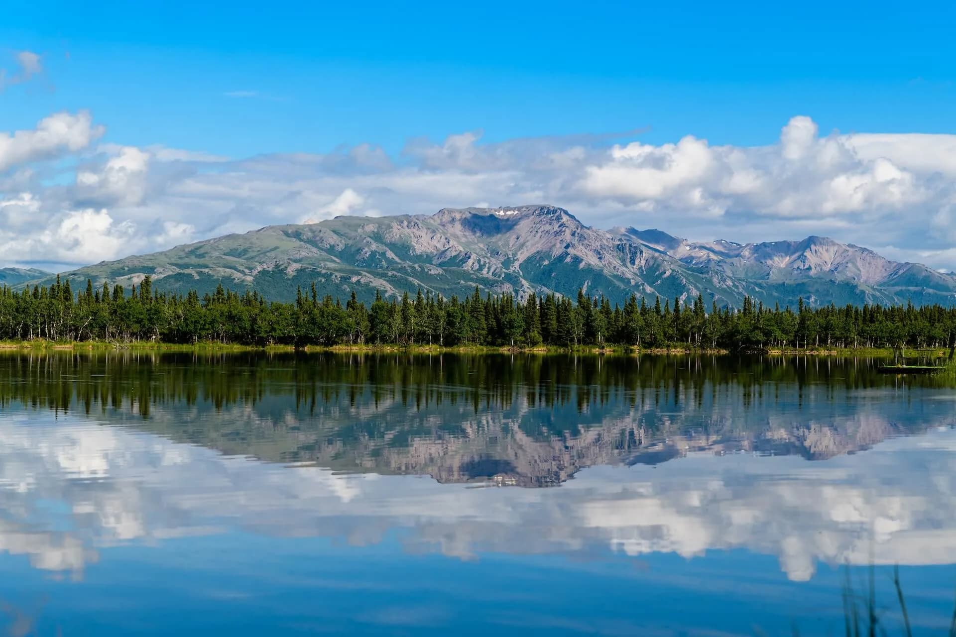 Alaskan mountain range and evergreen forest reflected in a still lake