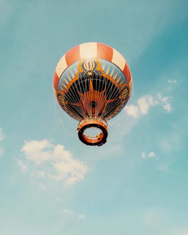 Striped hot air balloon floating in a blue sky