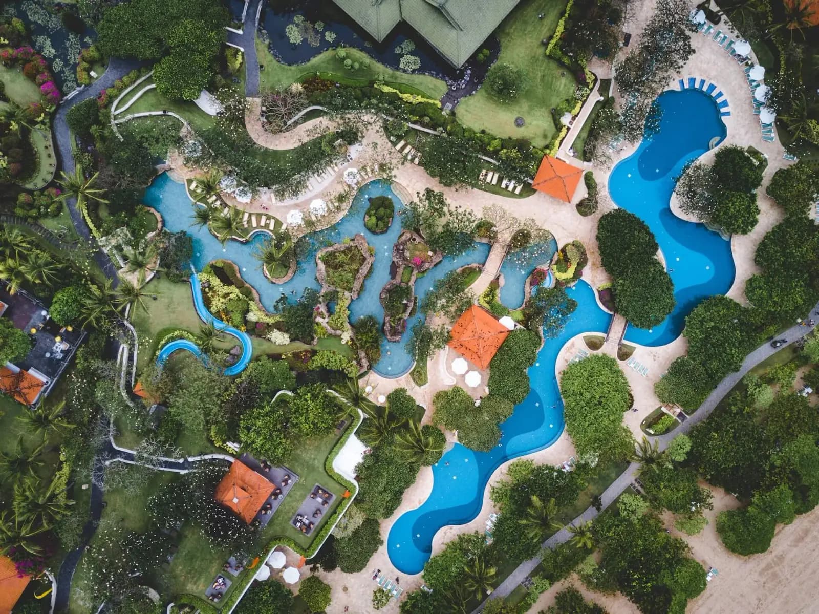 Palm trees and pools at a Caribbean all-inclusive resort beside turquoise water