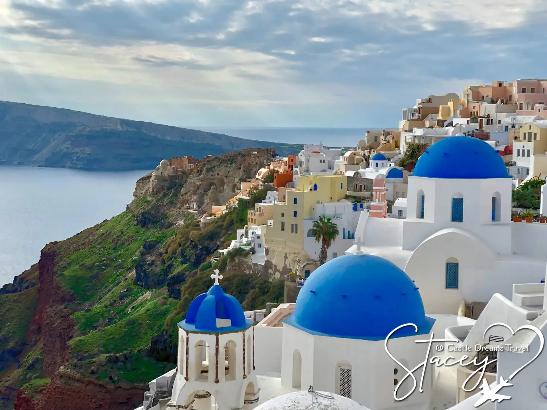 Blue-domed churches and whitewashed buildings above the sea cliffs of Santorini, Greece